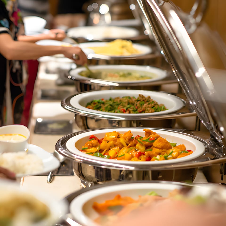 A buffet line at Charminar Indian Grill & Bar with various Indian dishes in chafing dishes.